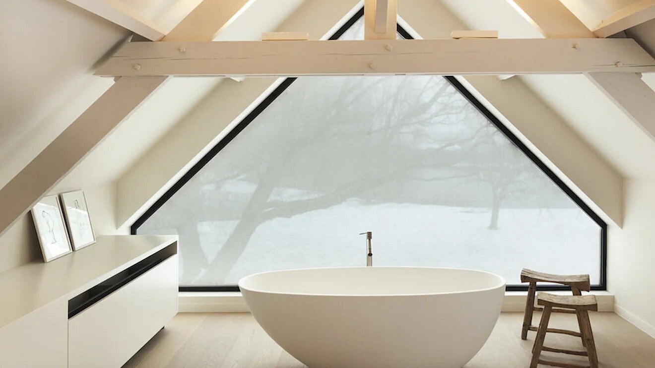 Badezimmer mit großem fünfeckigen Fenster, welches mit einem Hafttextil beklebt ist